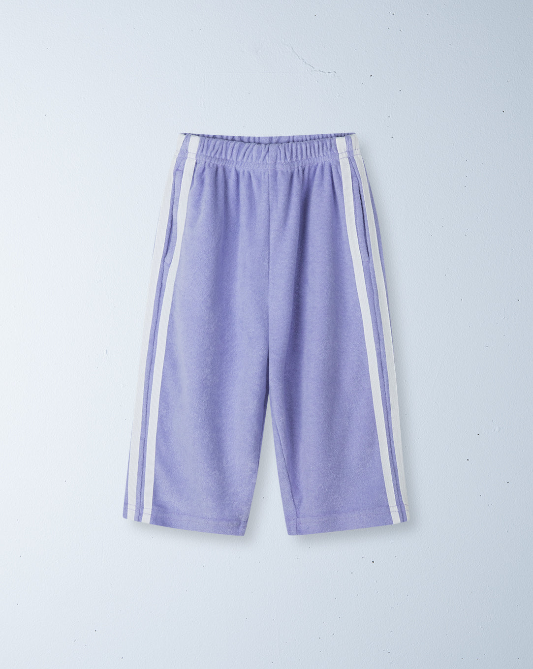 Purple pants with white stripes on a light gray background